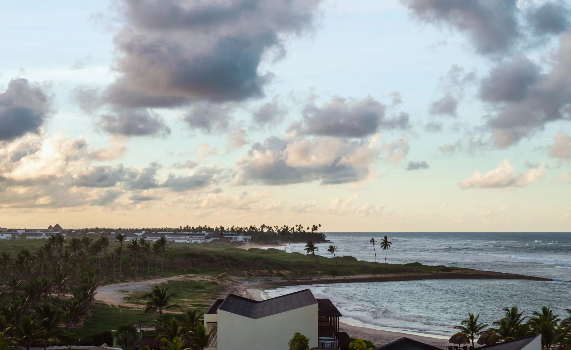 Costa tropical al atardecer con palmeras y mar Caribe